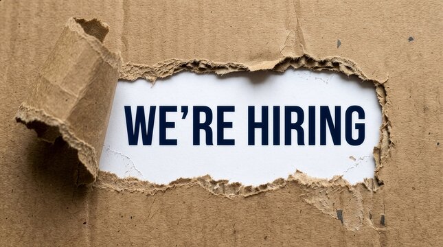 We Are Hiring Message Revealed Through Torn Brown Cardboard Paper