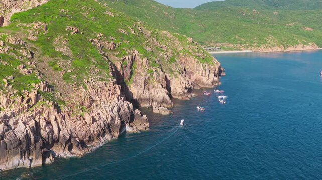 Aerial Drone View of Tourist Boats Along Granite Cliffs at Vinh Hy Bay, Ninh Thuan, Vietnam