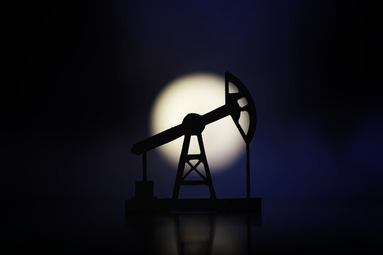 The crank balanced beam pumping unit under the curtain of night. Beam pumping unit under the night, closeup of photo