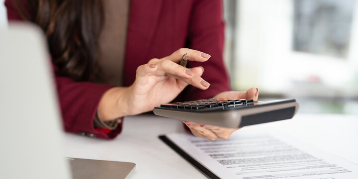 Finance, budgeting and tax calculation. Close up woman hand using calculator to calculate  finance, accounting.