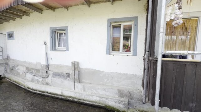 An artificial canal flows right past a house; the water flows quickly, panning shot