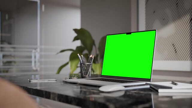 Laptop blank green screen mockup in a modern executive office interior and natural light. Luma matte and trackin clip included. 3d render