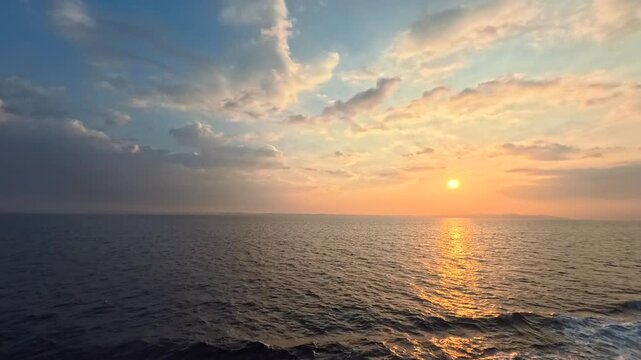 Real-time maritime sunrise footage under a colorful twilight gradient sky with clean horizon