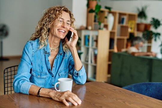 Portrait of a mature senior woman or a  businesswoman working from home having a meeting online, home office, or a student learning, or mature woman having a phone call, holding a mobile phone, smartp