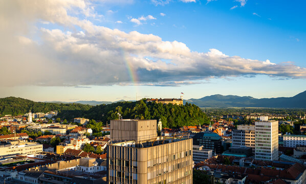 Panoramic view of Ljubljana city skyline with Ljubljana Castle and a rainbow after summer rain during golden hour in Slovenia showcasing European travel, culture and iconic Slovenian heritage