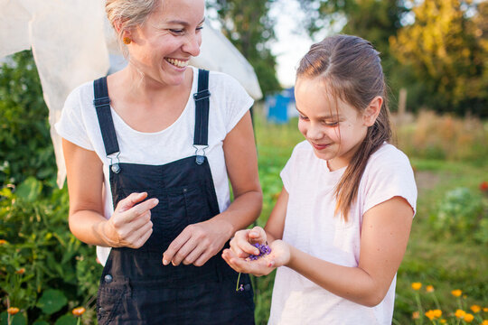 Smiling mother and daughter with fresh picked flowers