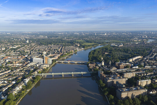 Aerial view of Putney Bridge spanning the River Thames, surrounded by urban residential areas, lush green trees, and city infrastructure in London, Greater London, United Kingdom.