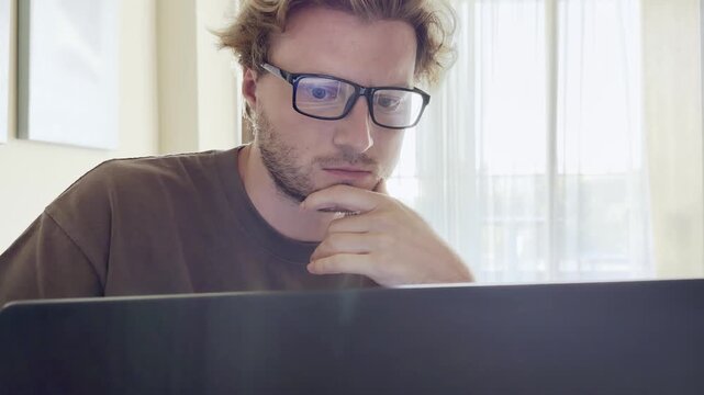 Young man working on computer at home,works remotely at a computer at home.