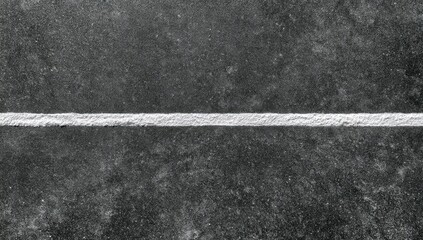 Fototapeta premium A stark white line bisects a dark, textured surface