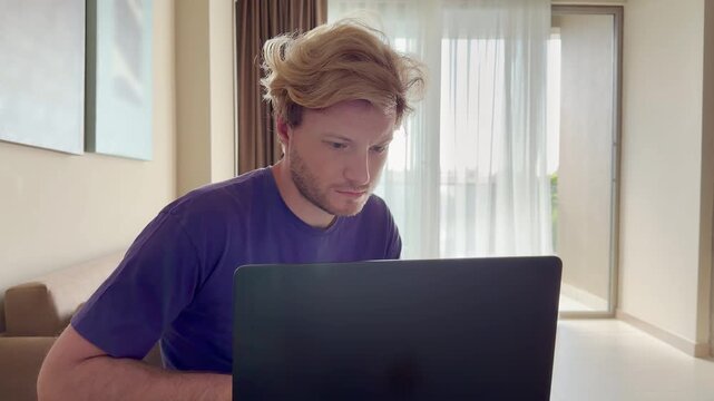Young man working on computer at home,works remotely at a computer at home.