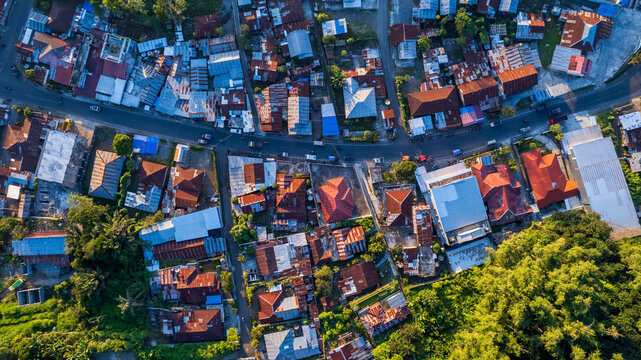 Aerial view of the town of Bajawa with its dense collection of residential rooftops, narrow streets, and lush green vegetation in Bajawa, Nusa Tenggara Timur, Indonesia.