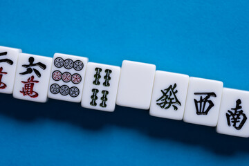 Fototapeta na wymiar 青背景に並ぶマージャン牌 