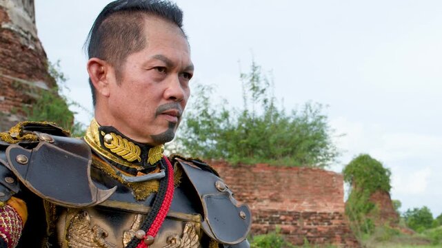 Thai Warrior in Ancient Armor Standing Near Historical Temple Ruins