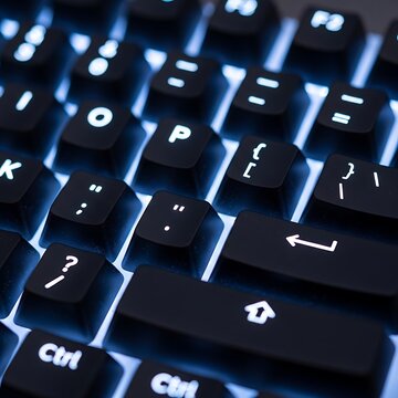 Close up view of a computer keyboard with blue backlighting.