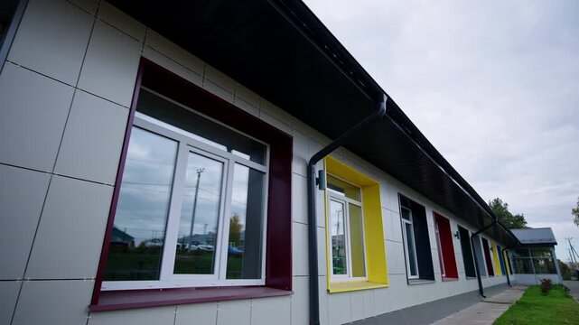 Linear rows of vivid windows decorate contemporary educational facility. Fresh minimal design looks charming, spacious and organized