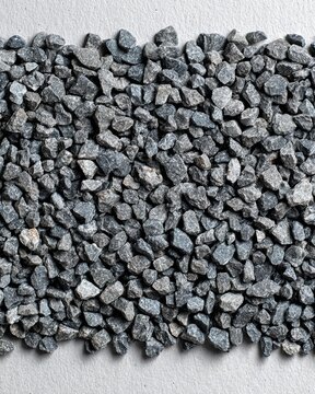 A densely packed pile of small, grey crushed gravel stones forming a textured background
