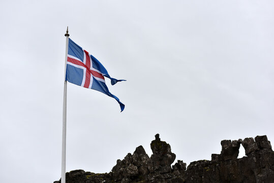 National flag of Iceland against a cloudy sky