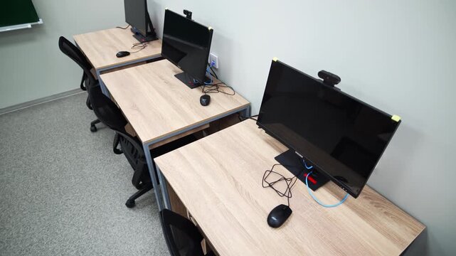 Professional digital equipment features screens and comfortable office chairs. Silent indoor environment feels ready for serious study