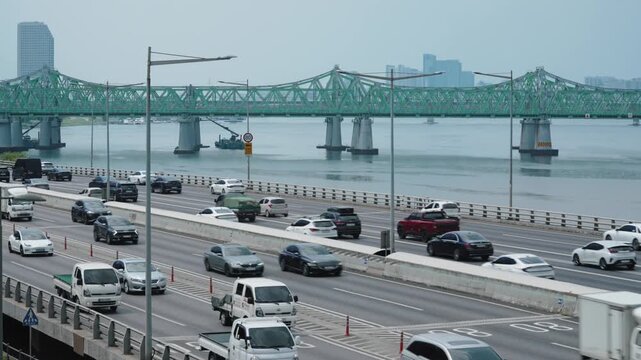 Seoul Han river highway traffic with green bridge.
