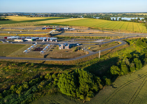 Aerial view of MOP Znin Zachod rest area with parked trucks, surrounding green agricultural fields, and trees in Znin-Wies, Kujawsko-Pomorskie, Poland.