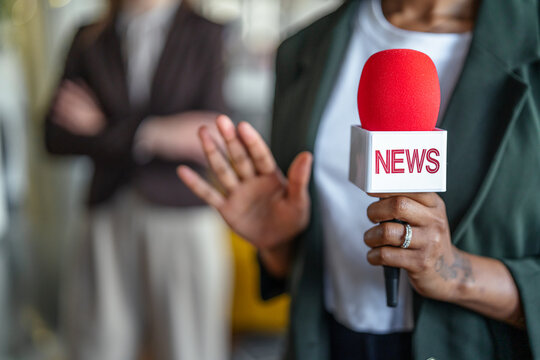 Reporter holding news microphone interviewing person refusing to speak