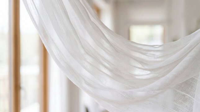 Sheer white curtain fabric billows softly, capturing gentle movement and airy natural light within a serene interior.