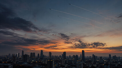 Fototapeta premium Military Jets Flying in Formation Over City Skyline at Sunset