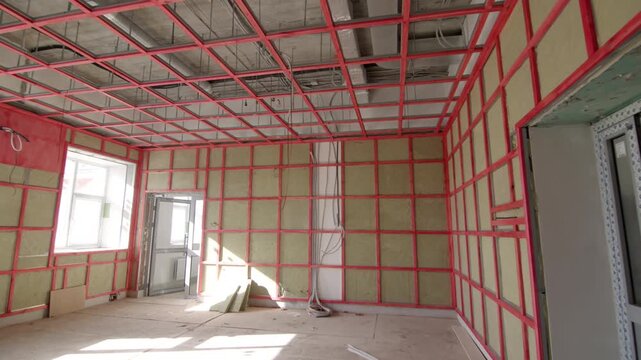 Geometric timber grid covers interior walls and open ceiling structure. Empty dusty environment looks ready for active renovation work
