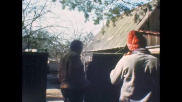 Men talk in yard of rural home, discussing farm work. Household tasks. Authentic countryside cooperation, community life. activities in village. Old film. Archival retro 1970s. Vintage archive
