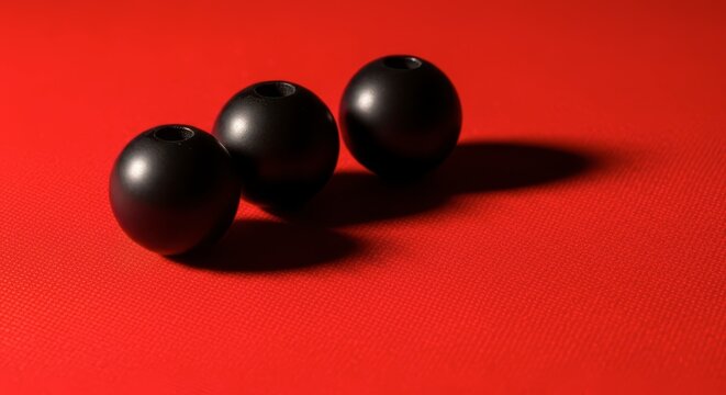 Three black balls on red background.