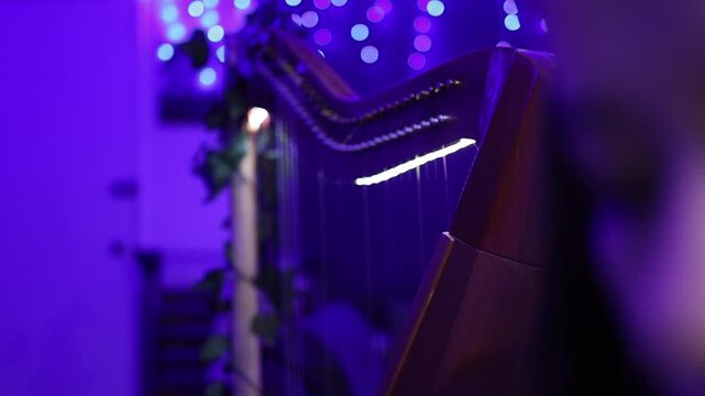 Intimate close-up shot of a harpist playing in soft blue lighting, with dreamy bokeh effects and detailed focus on strings and facial expression, creating a calm, artistic mood.