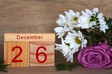 December 26, wooden calendar with colorful fresh flowers