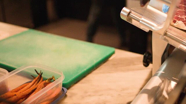 Professional Chef Slicing Cured Meat with Electric Deli Slicer