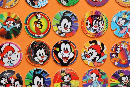 Salvador, Brazil - July 1, 2026: Vintage Animaniacs collectible plastic Tazos by Warner Bros. Retro childhood memories, nineties nostalgia. Elma Chips and Frito Lay tazos. 