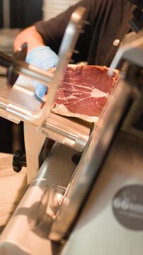 Professional Chef Slicing Cured Meat with Electric Deli Slicer