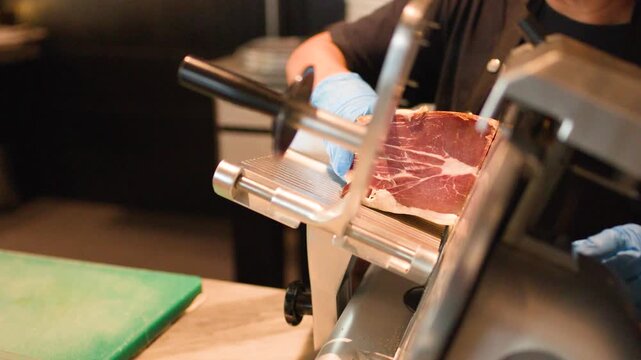 Professional Chef Slicing Cured Meat with Electric Deli Slicer