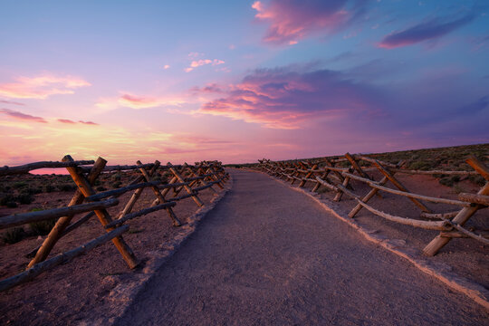 sunset in the desert,  pathway with wooden barriers on a desert,  Arizona