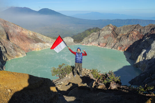 Hiker Proudly Waving The Indonesian Flag at Summit of Mount Ijen Crater in Banyuwangi