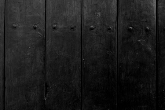  Tablones de madera viejos de color negro oscuro con pernos de metal, textura grunge. Tablones de madera desgastados de color oscuro con textura de pernos de metal; fondo grunge industrial.