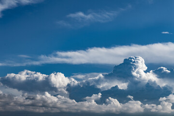 Fototapeta premium Dramáticos cúmulos de nubes de tormenta blancas contra un cielo azul profundo. Imponentes cúmulos de nubes de tormenta blancas sobre un cielo azul profundo; espectacular fondo meteorológico