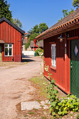 Idyllic old red wooden cottages in an cobblestone alley a sunny summer day © Lars Johansson