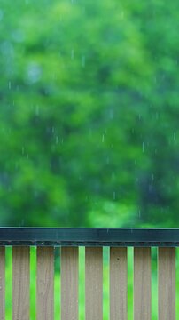 Raing on soft focus blurred background featuring lush green foliage with dreamy bokeh effect and fence, creating a serene tranquil atmosphere nature-themed projects