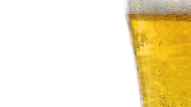 A glass of beer with a lot of bubbles in it, close-up view, space for text on a white background