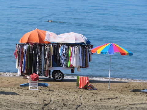 Beach trader selling clothes to a local tourist at Marina di Latina, Italy

