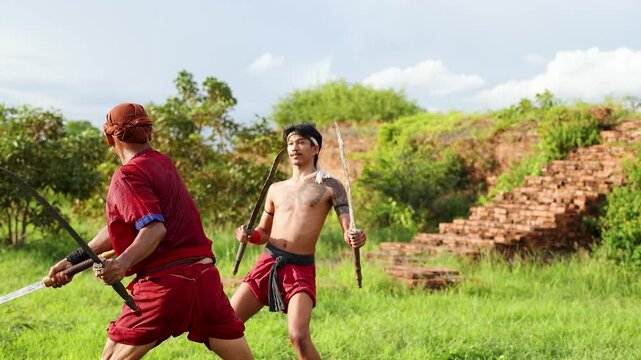 Traditional Thai Warriors Sword Fighting Near Ancient Brick Ruins