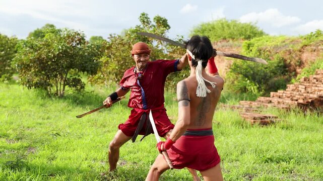 Two Men in Traditional Red Garments Practicing Sword Fighting at Ancient Ruins