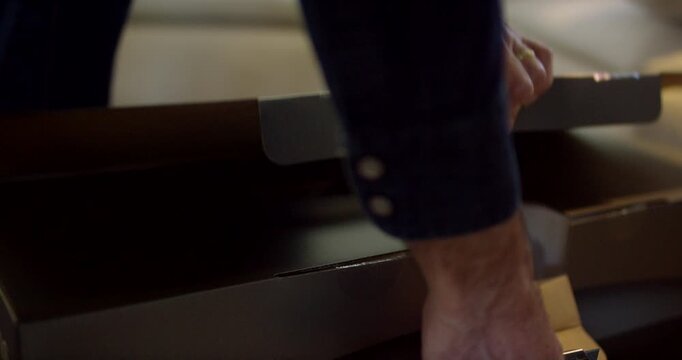 Close up of a man inserting a black two pin electrical plug into a white wall socket