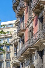 Obraz premium Classic Red Brick Building Facade with Iron Balconies in Barcelona, Architecture, Residential House