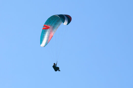Vol en parapente dans un ciel bleu azur d'&eacute;t&eacute; en montagne. Voile multicolore. 