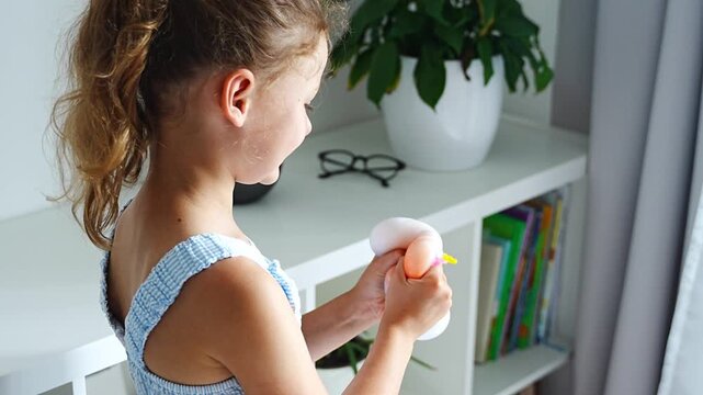 Child squeezes a soft squishy stress relief toy at home. Sensory play supports emotional regulation, relaxation and focus through tactile interaction.